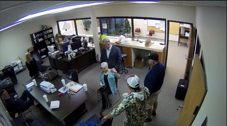 Surveillance video of the Coffee County elections office shows election skeptic Scott Hall giving county Republican Party Chairwoman Cathy Latham a massage on Jan. 7, 2021, the day tech experts copied confidential voting data. Also pictured are Paul Maggio and Jennifer Jackson of SullivanStrickler, county elections board member Eric Chaney and an unidentified man. Source: Coffee County