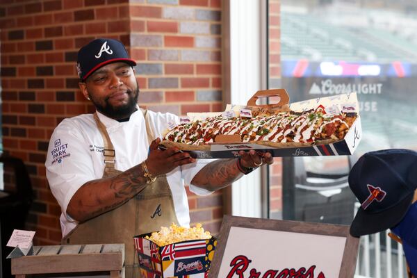 Sous-chef Chris Person holds the specialty food item Grand Slam Nacho during media day at Truist Park, Tuesday, March 26, 2024, in Atlanta. (Jason Getz / jason.getz@ajc.com)