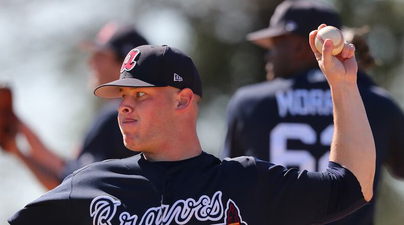 A.J. Minter delivers a pitch during a bullpen session Thursday on the second day of Braves pitchers-and-catchers workouts. Curtis Compton/ccompton@ajc.com
