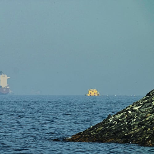 An Emirati patrol boat, left, is near a tanker anchored in the Gulf of Oman near the Strait of Hormuz, as seen from a coastal road near Khor Fakkan, United Arab Emirates, Friday, May 1, 2026. (AP Photo/Fatima Shbair)
