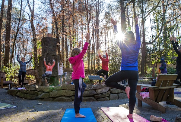 Marking the official beginning of winter, Dunwoody Nature Center holds an outdoor yoga class on the solstice where 8-year-old Kate McKeveny, left, and her mother, Linda McKeveny, right, participate in the hour-long class Monday, Dec 21, 2020.  (Jenni Girtman for The Atlanta Journal-Constitution)