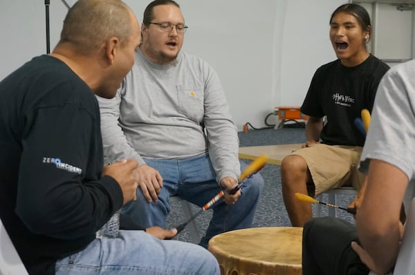 New graduate Arthur Lockwood, center left, and other members of the Prairie Island Singers perform drumming at a ceremony honoring high school and higher education graduates at the Prairie Island Indian Community in Minnesota on Wednesday, July 9, 2025. (AP Photo/Giovanna Dell'Orto)