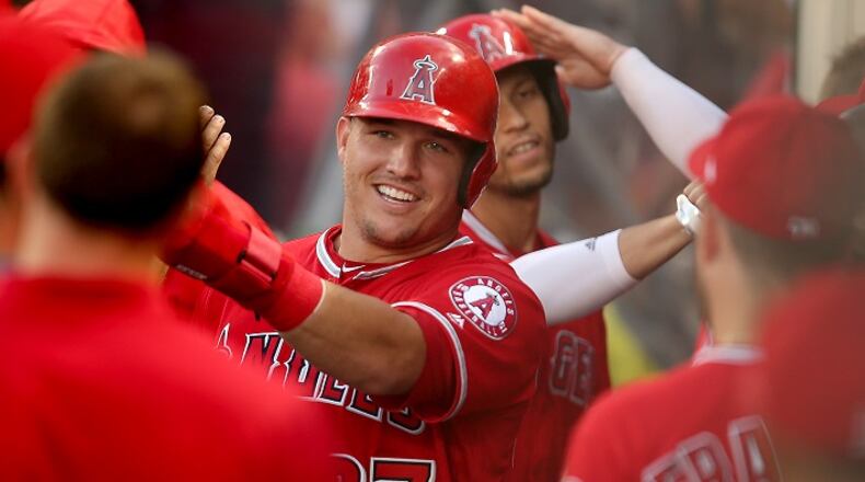 The Los Angeles Angels' Mike Trout and Andrelton Simmons are congratulated by teammates after Simmons' sacrifice fly scored Trout in the first inning against the Washington Nationals on July 19, 2017, at Angel Stadium of Anaheim, Calif. (Luis Sinco/Los Angeles Times/TNS)