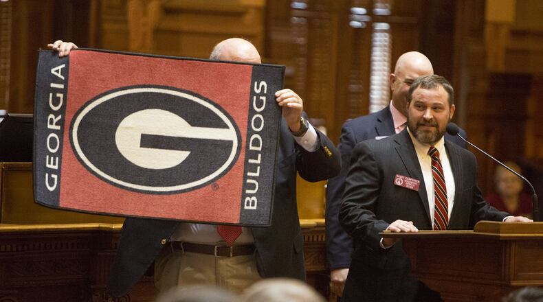 Newly minted member of the Georgia House of Representatives Kasey Carpenter (right) presents Speaker David Ralston with a Georgia Bulldogs rug during the first day of the 2018 General Assembly at the Georgia State Capitol on Monday January 8th, 2018. The assembly adjourned after about an hour of business because of the national football championship. (Photo by Phil Skinner)