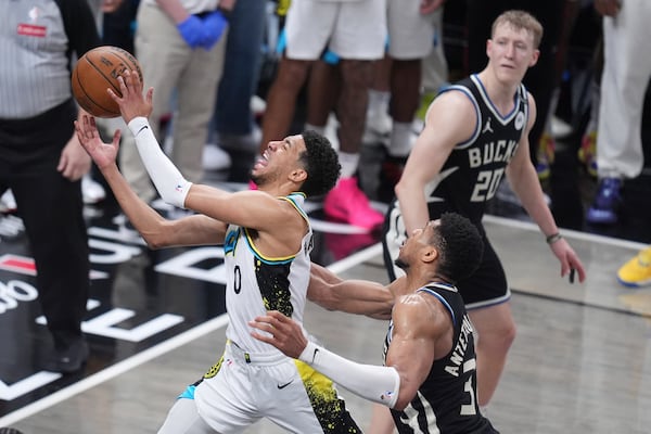 Indiana Pacers guard Tyrese Haliburton (0) shoots the ball past Milwaukee Bucks forward Giannis Antetokounmpo, right, during the second half in Game 5 of an NBA basketball first-round playoff series in Indianapolis, Tuesday, April 29, 2025. (AP Photo/Michael Conroy)