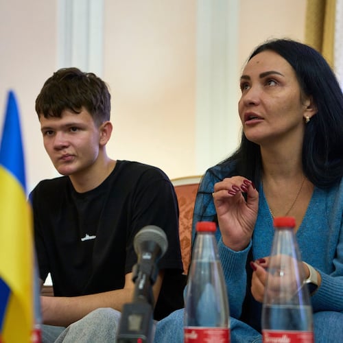 Mark Razvozov, left, listens to his mother Yukiia Dvornychenko, during a press conference on the return of Ukrainian children and civilians taken by Russia during the three-and-a-half-year war, at the Embassy of Ukraine in Italy, in Rome, Wednesday, Nov. 19, 2025. (AP Photo/Domenico Stinellis)