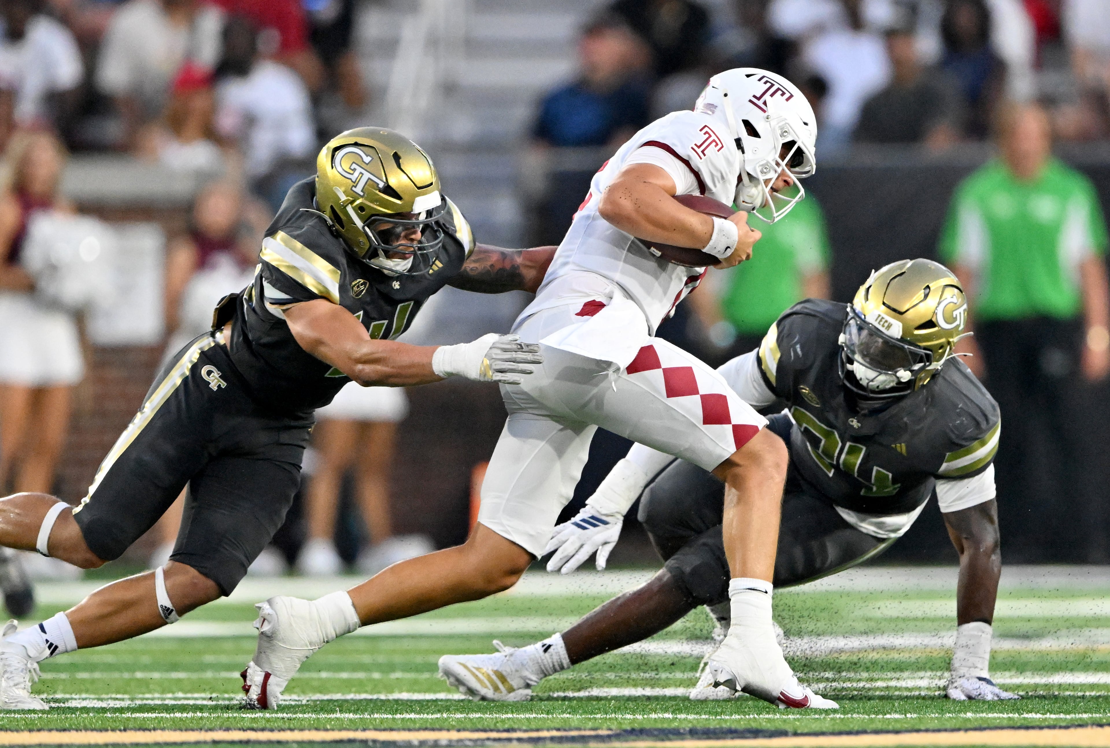 Temple quarterback Evan Simon (center) gets sacked by Georgia Tech linebacker Kyle Efford (left) and Georgia Tech defensive lineman Ronald Triplette during the second half of an NCAA college football game at Georgia Tech's Bobby Dodd Stadium, Saturday, November 20, 2025 in Atlanta. Georgia Tech won 45-24 over Temple. (Hyosub Shin / AJC)