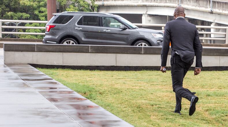Jim Beard, the city of Atlanta's former CFO, leaves the Richard B. Russell Federal Building in Atlanta, jogging to the car of one of his attorneys, Brittany Cambre, on Thursday, Sept 17, 2020. Beard had just entered a plea of not guilty to multiple federal charges. (Jenni Girtman for The Atlanta Journal-Constitution)