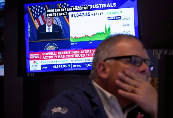 FILE - Trader Michale Conlon, right, works on the floor of the New York Stock Exchange as Federal Reserve Chair Jerome Powell's news conference appears on a television screen behind him, Sept. 18, 2024. (AP Photo/Richard Drew, file)