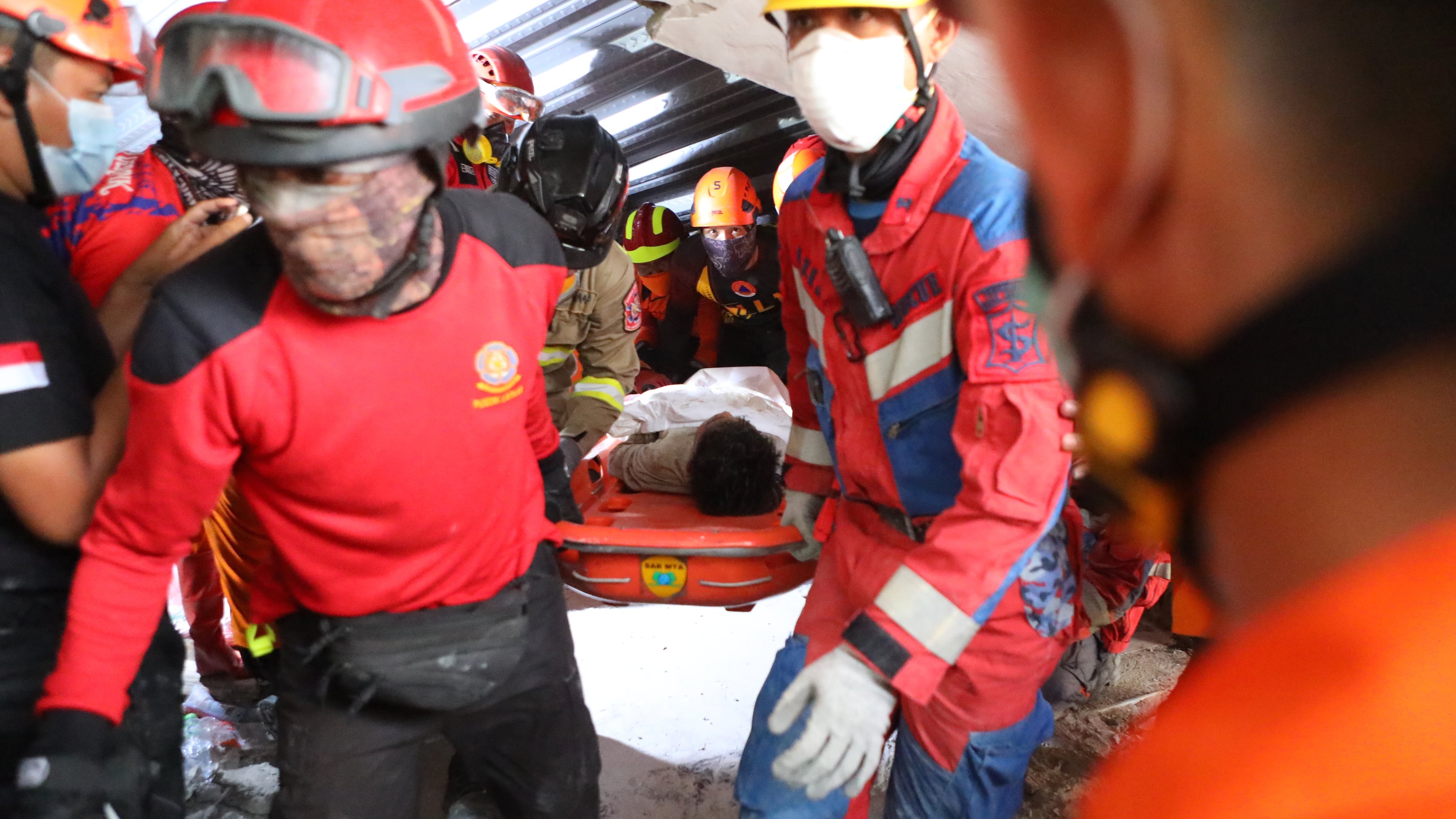 Rescuers carry a survivor who was pulled out from the rubble after a building under construction collapsed at an Islamic boarding school in Sidoarjo, East Java, Indonesia, Wednesday, Oct. 1, 2025. (AP Photo/Alam Syahirul)