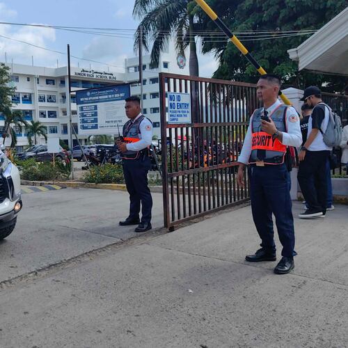 Security guards keep watch as vehicles exit the Ateneo de Zamboanga University following a shooting incident in Zamboanga, southern Philippines Tuesday, Aug. 18, 2026. (AP Photo)