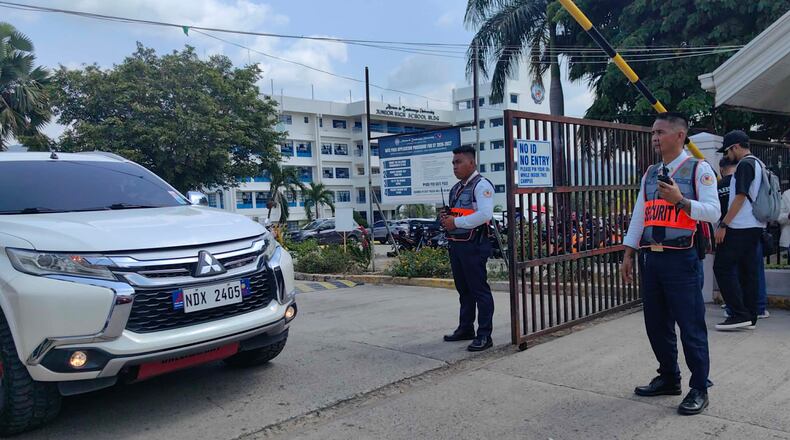 Security guards keep watch as vehicles exit the Ateneo de Zamboanga University following a shooting incident in Zamboanga, southern Philippines Tuesday, Aug. 18, 2026. (AP Photo)