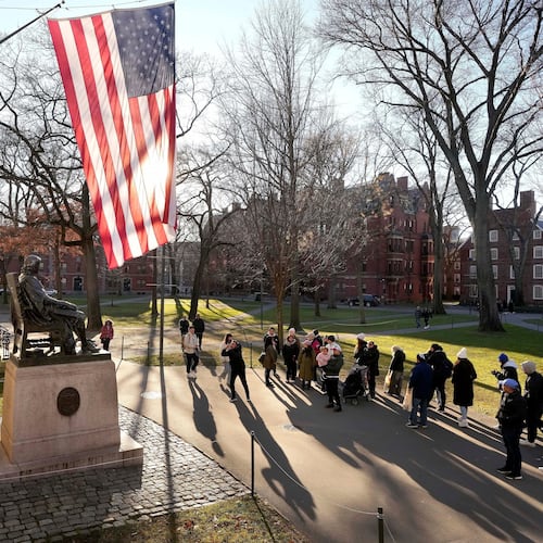 FILE - People take photos near a John Harvard statue, left, on the Harvard University campus, Jan. 2, 2024, in Cambridge, Mass. (AP Photo/Steven Senne, File)
