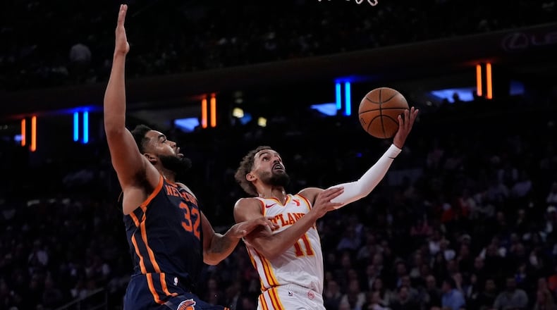 Atlanta Hawks' Trae Young (11) drives past New York Knicks' Karl-Anthony Towns (32) during an Emirates Cup NBA basketball game Wednesday, Dec. 11, 2024, in New York. (AP Photo/Frank Franklin II)