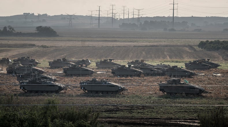 Israeli tanks on a field as they prepare to move towards the Gaza Strip, outside Erez, Israel, on Sunday, Oct. 15, 2023. (Sergey Ponomarev/The New York Times)