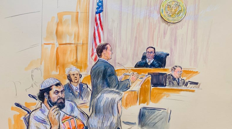 This courtroom sketch depicts Rahmanullah Lakanwal, 29, seated left, with defense attorney Michelle Peterson, seated foreground, before U.S. District Judge Amit Mehta, Feb. 4, 2025 at Federal Court in Washington, as Assistant U.S. Attorney Christopher Tortorice speaks at the podium. (Dana Verkouteren via AP)