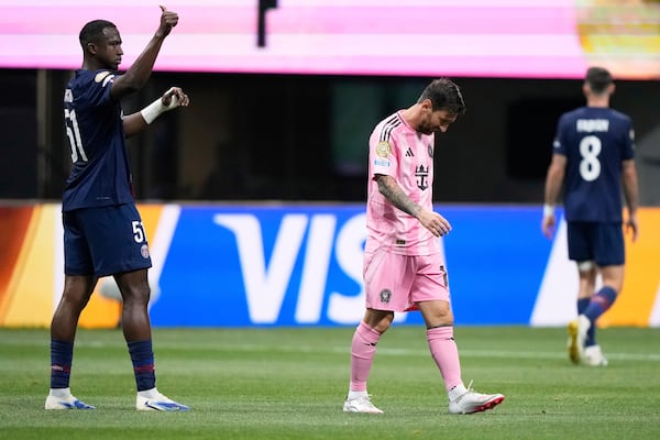 Paris Saint-Germain's Willian Pacho, left, signals as Inter Miami's Lionel Messi, center, walks away during the Club World Cup round of 16 soccer match between PSG and Inter Miami in Atlanta, Sunday, June 29, 2025. (AP Photo/Brynn Anderson)