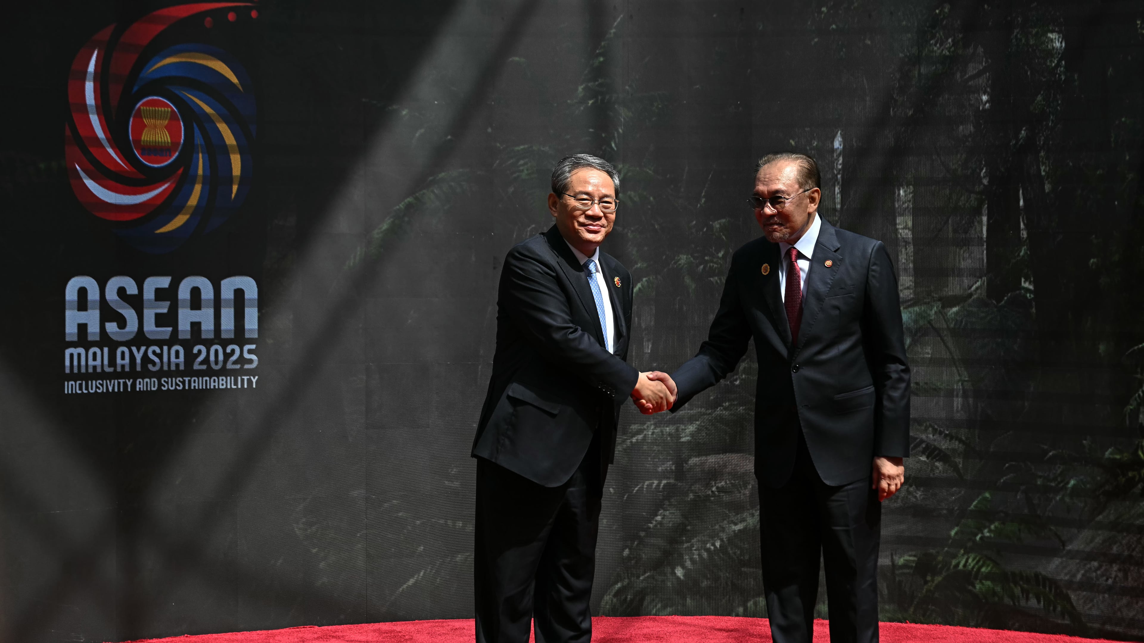 China's Premier Li Qiang, left, shakes hands with Malaysia's Prime Minister Anwar Ibrahim as he arrives at the Kuala Lumpur Convention Centre to attend the 47th Association of Southeast Asian Nations (ASEAN) summit in Kuala Lumpur, Malaysia, Monday, Oct. 27, 2025. (Lillian Suwanrumpha/Pool Photo via AP)