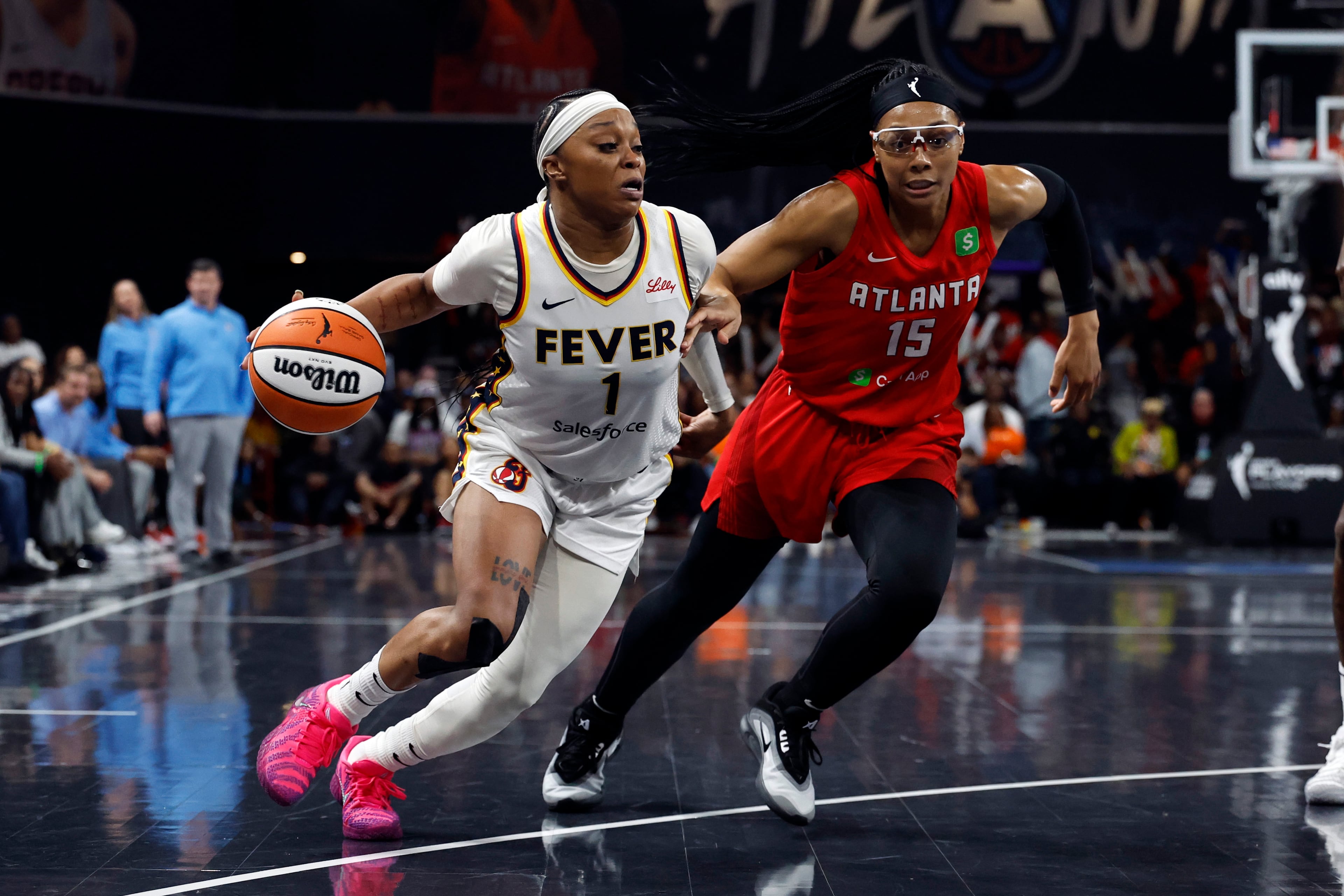 Indiana Fever guard Odyssey Sims (1) drives to the basket around Atlanta Dream guard Allisha Gray (15) during the first half of Game 3 in the first round of the WNBA basketball playoffs, Thursday, Sept. 18, 2025, in Atlanta. (AP Photo/Butch Dill)