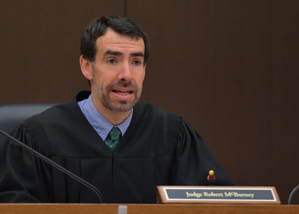 Fulton County Superior Court Chief Judge Robert McBurney confers with prosecutors and defense attorneys while waiting for a late juror on Day 8 of the Tex McIver murder trial at Fulton County Courthouse on Thursday, March 22, 2018. HYOSUB SHIN / HSHIN@AJC.COM