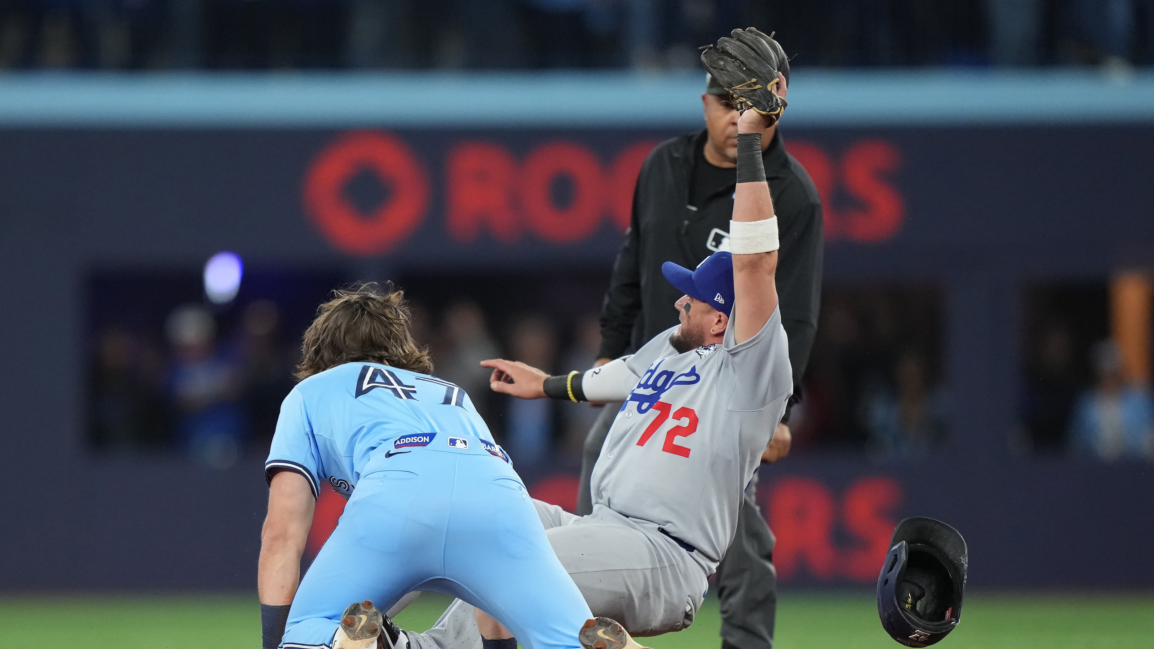 Los Angeles Dodgers second baseman Miguel Rojas (72) shows the ball to the umpire after forcing out Toronto Blue Jays' Addison Barger (47) at second to turn a double play to end the game during ninth inning Game 6 World Series playoff MLB baseball action in Toronto on Friday, Oct. 31, 2025. (Nathan Denette/The Canadian Press via AP)