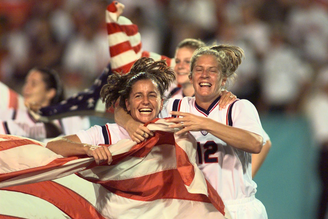 Joy Fawcett (left) and Carin Gabarra (right) run around Sanford Stadium in Athens with an American flag after their historic 2-1 gold medal win over China during the 1996 Summer Olympic Games. (David Tulis/AJC)