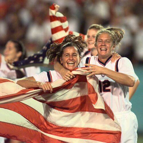 Joy Fawcett (left) and Carin Gabarra (right) run around Sanford Stadium in Athens with an American flag after their historic 2-1 gold medal win over China during the 1996 Summer Olympic Games. (David Tulis/AJC)