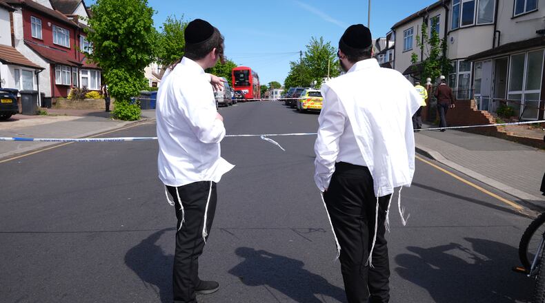 Members of the Jewish community at the scene where two people were stabbed Wednesday April 29, 2026 in a London neighborhood with a large Jewish community and a 45-year-old man was arrested on suspicion of attempted murder over what authorities called an antisemitic attack. (Lucy North/PA via AP)