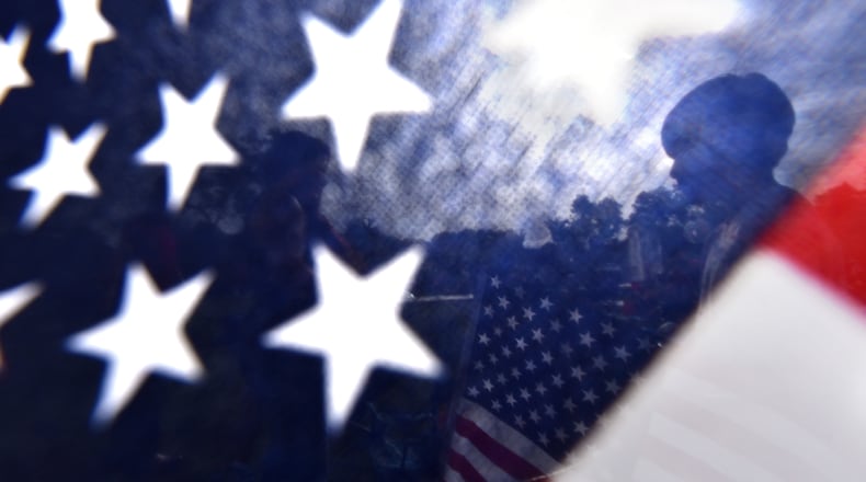 Harold Rivera, 10, sets up the American flag with his family at Lillian Webb Park during a Pre-Fourth of July block party in Downtown Historic Norcross on Friday, July 3, 2015. Made with a Nikon D750 camera, 17-35MM lens at focal length 17MM, 1/800 second, F10, and an ISO of 400. HYOSUB SHIN / HSHIN@AJC.COM