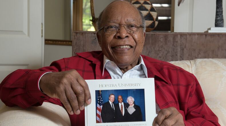 Dr. Louis Sullivan, of Atlanta, holds his photograph with the late President George H.W. Bush and the late Barbara Bush that was taken in 1997. Sullivan was appointed by Bush and served as the secretary of the U.S. Department of Health and Human Services from 1989 to 1993. He was the founding dean and president emeritus of Morehouse School of Medicine. HYOSUB SHIN / HSHIN@AJC.COM