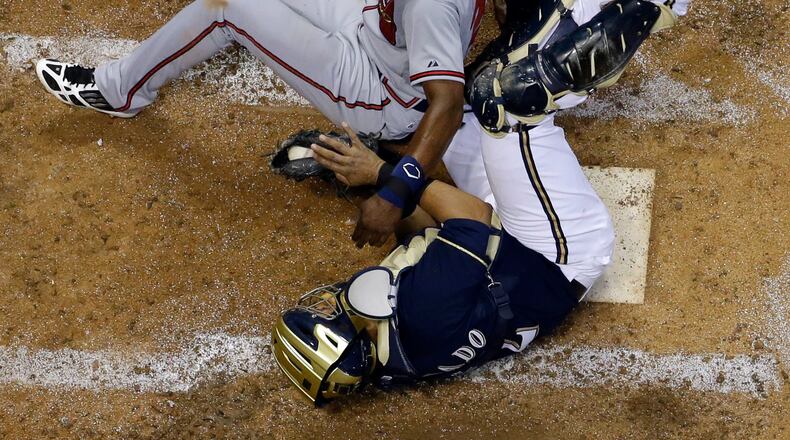 Brewers catcher Martin Maldonado holds onto the ball as Atlanta Braves' B.J. Upton is forced out on a suicide squeeze by Julio Teheran during the fifth inning of a baseball game Friday, June 21, 2013, in Milwaukee