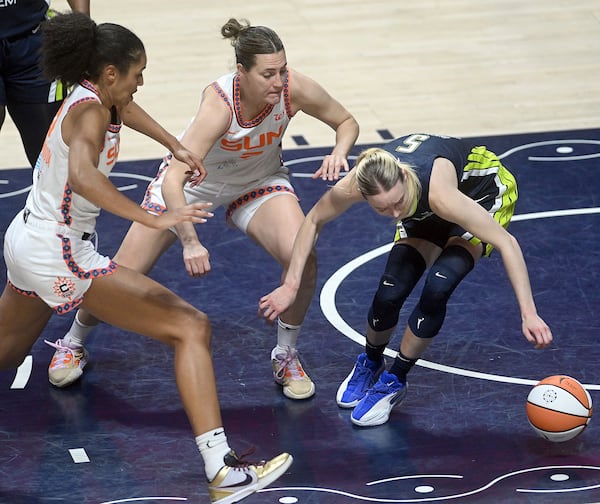 Dallas Wing's Paige Bueckers, right, and Connecticut Sun's Haley Peters, center, and Olivia Nelson-Ododa push for a rebound during a WNBA basketball game Tuesday, May 27, 2025, in Uncasville, Conn. (Sarah Gordon/The Day via AP)