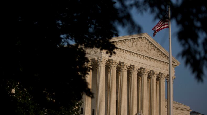 The American flag flies next to the U.S. Supreme Court in Washington, D.C., U.S., on Thursday, June 11, 2015. The U.S. Supreme Court is poised to issue blockbuster rulings on same-sex marriage and health care with both rulings due by the end of June as the court finishes its nine-month term with its traditional flurry of major opinions. Photographer: Andrew Harrer/Bloomberg