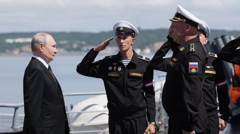 Russian President Vladimir Putin, left, visits the Varyag missile cruiser of the Pacific Fleet to watch a military exercise near Yuzhno-Sakhalinsk, on Sakhalin Island, Russia, Wednesday, Aug. 12, 2026. (Gavriil Grigorov, Sputnik, Kremlin Pool Photo via AP)