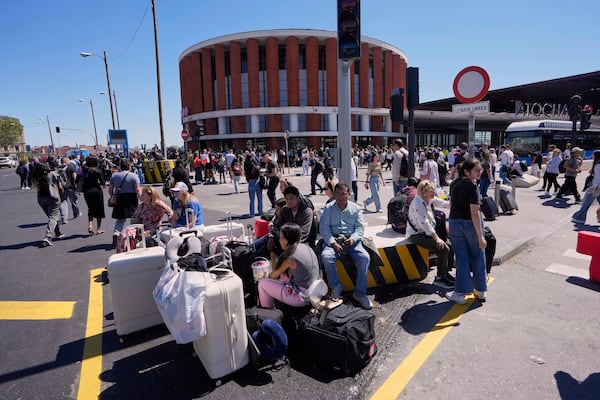 Passengers roam outside Atocha train station during a nationwide power outage in Madrid, Monday, April 28, 2025. (AP Photo/Manu Fernandez)