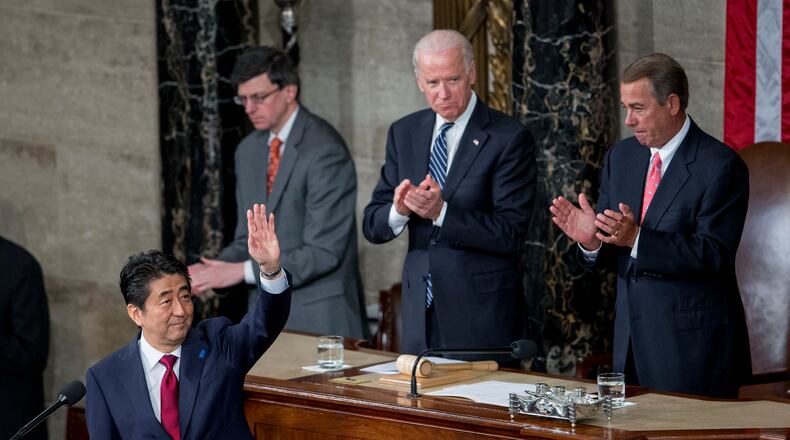 Shinzo Abe, Japan's prime minister, left, waves after speaking during a joint meeting of Congress with U.S. House Speaker John Boehner, a Republican from Ohio, right, and, U.S. Vice President Joseph "Joe" Biden, top left, in the House Chamber at the U.S. Capitol in Washington, D.C., U.S., on Wednesday, April 29, 2015. Abe urged the U.S. to work closely with his country in pushing through an ambitious Asia-Pacific trade deal that he says also will promote both democracy and freedom in that region. Photographer: Andrew Harrer/Bloomberg *** Local Caption *** Shinzo Abe; John Boehner; Joe Biden Shinzo Abe, Japan's prime minister, left, waves after speaking last week during a joint meeting of Congress with U.S. House Speaker John Boehner, a Republican from Ohio, right, and, U.S. Vice President Joe Biden. Abe urged the U.S. to work closely with his country in pushing through an ambitious Asia-Pacific trade deal that he says also will promote both democracy and freedom in that region. Andrew Harrer/Bloomberg