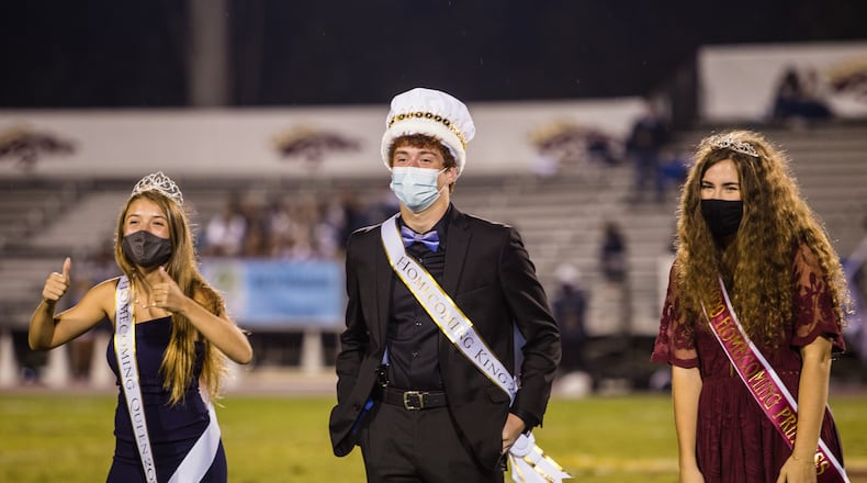 Brookwood High School in Snellville celebrates homecoming without a parade or a dance Friday, Oct 9, 2020. The homecoming court did participate in the traditional half-time event of the evening where the school crowned the king and queen and prince and princess of homecoming for the 2020 school year. Lux Corrona, was crowned homecoming queen, from left, with king Michael Hearnes and princess Bailey Parker. (Jenni Girtman for The Atlanta Journal-Constitution)