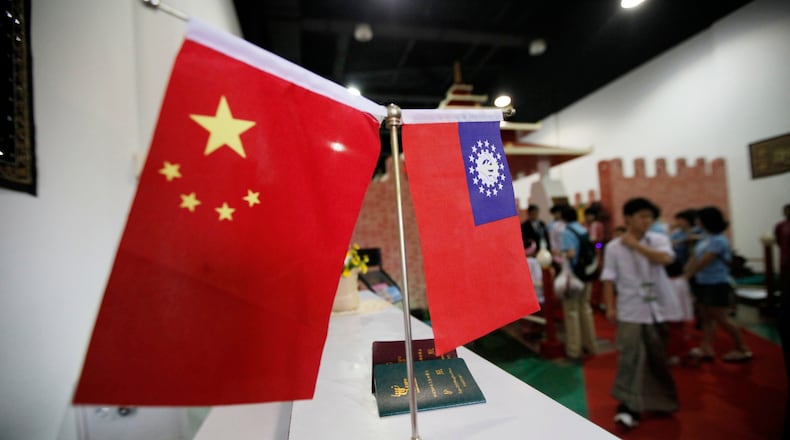 FILE - Flags of China and Myanmar are displayed at the entrance of Myanmar Pavilion prior to Myanmar's top junta leader Gen. Than Shwe to arrive at the Shanghai Expo site in Shanghai Friday, Sept.10, 2010. (AP Photo/Eugene Hoshiko, file)