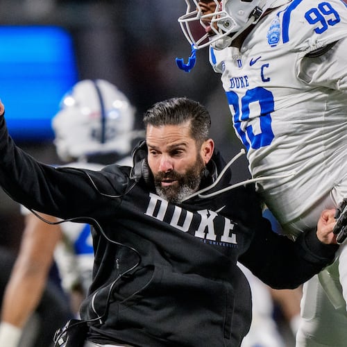 Duke head coach Manny Diaz, left, celebrates with defensive tackle Aaron Hall (99) after Virginia missed a field goal in the first half of the Atlantic Coast Conference championship NCAA college football game Saturday, Dec. 6, 2025, in Charlotte, N.C. (AP Photo/Jacob Kupferman)