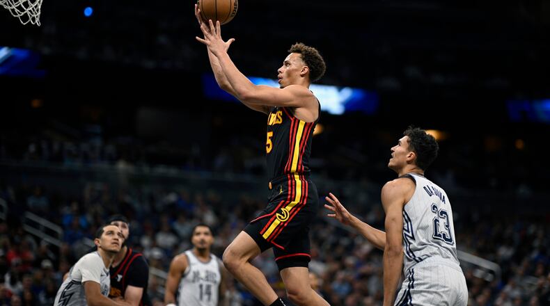 Atlanta Hawks guard Dyson Daniels (5) goes up to shoot as Orlando Magic guard Anthony Black, left, guard Gary Harris (14) and forward Tristan da Silva (23) look on during the first half of an NBA basketball game, Monday, Feb. 10, 2025, in Orlando, Fla. (AP Photo/Phelan M. Ebenhack)