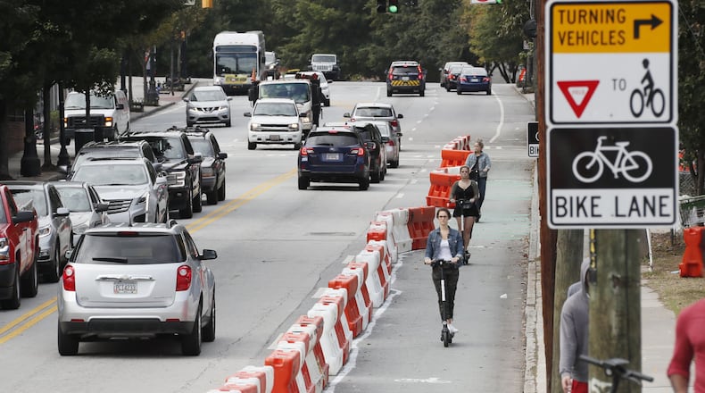 E-scooter riders make their way down 10th Street in the lane that was restricted to bikes and scooters for a week in October. The temporary bike lane was a part of the mayor’s $5 million plan to triple the city’s network of protected lanes for bicycles and scooters by the end of 2021. BOB ANDRES / ROBERT.ANDRES@AJC.COM