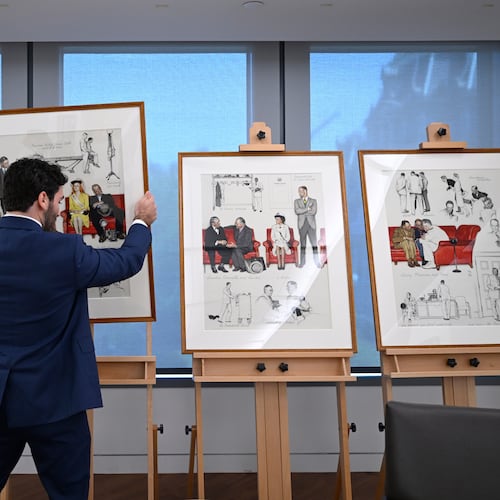 Luke Boorady, of the White House Historical Association, arranges a suite of four interrelated paintings by Norman Rockwell titled, "So You Want to See the President!" at the association's offices Wednesday, June 10, 2026, in Washington. (AP Photo/John McDonnell)