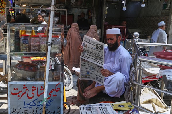 A Pakistani man reads morning news paper with front page story about Pakistan and India military tension, at a market in Peshawar, Pakistan, Friday, May 9, 2025. (AP Photo/Muhammad Sajjad)
