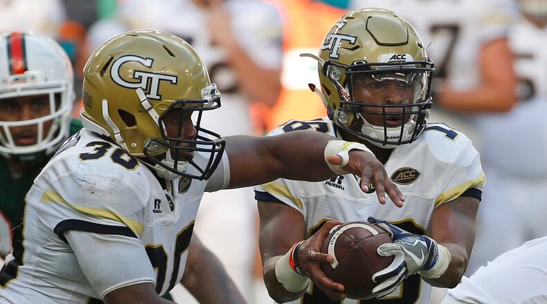 Georgia Tech quarterback TaQuon Marshall (right) fakes a handoff to running back KirVonte Benson (30) against Miami, Saturday, Oct. 14, 2017 in Miami Gardens, Fla.