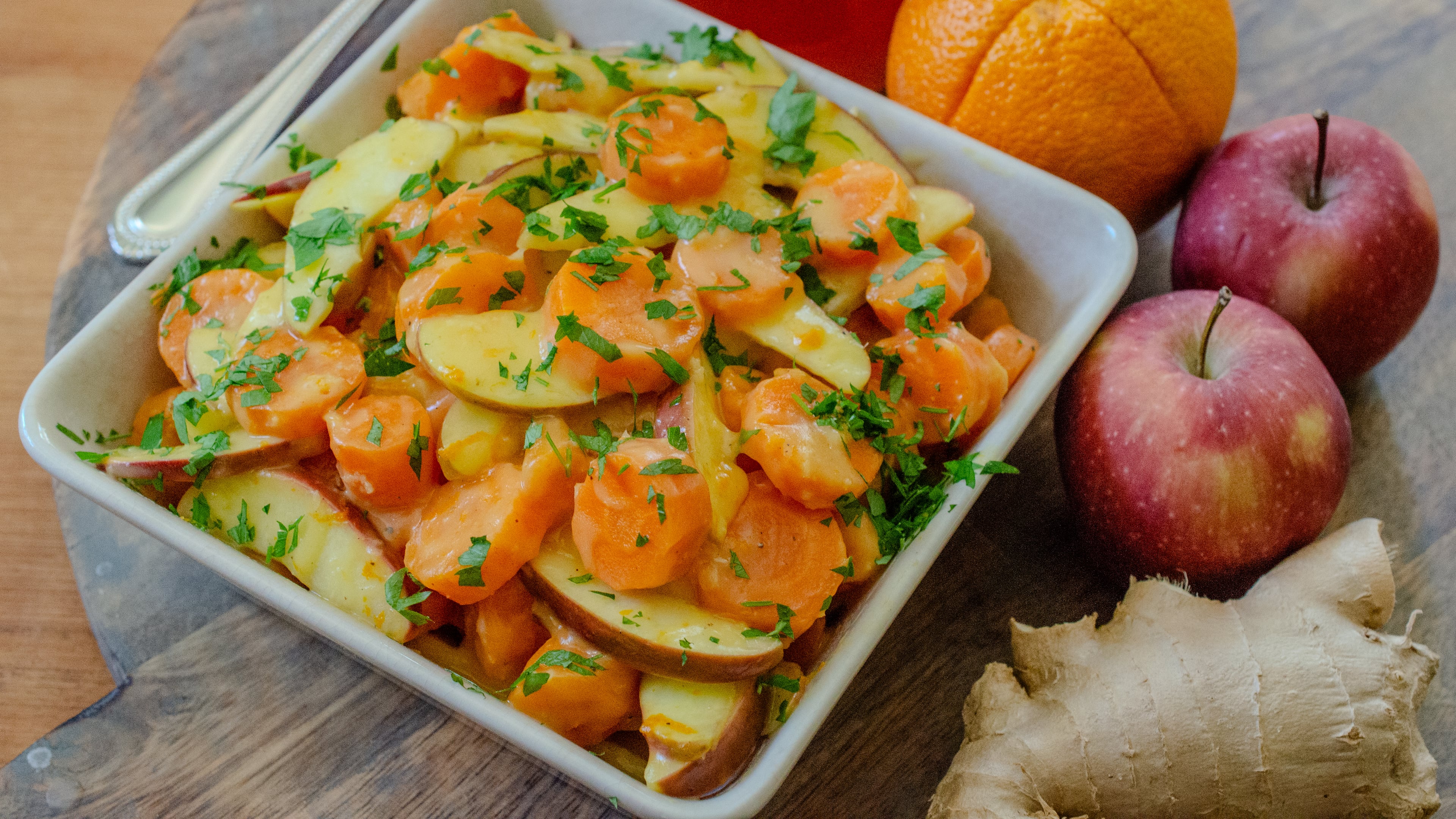 Crispy, tender carrots and apples are combined in a light orange and ginger glaze for a brightened Carrot Apple Tzimmes. (Virginia Willis for the AJC)