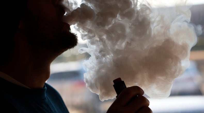 FILE - In this Friday, Jan. 18, 2019 file photo, a customer blows a cloud of smoke from a vape pipe at a local shop in Richmond, Va. Although e-cigarettes arent considered as risky as regular cigarettes, new research published Monday, May 27, 2019, finds a clue that their flavorings may be bad for the heart. (AP Photo/Steve Helber)