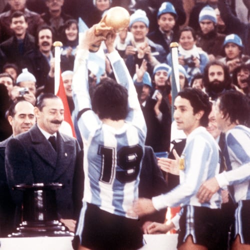 FILE - Argentine President Jorge Rafael Videla, center, looks on after he presented the World Cup Trophy to Argentina's captain Daniel Passarella (19), at the presentation ceremony following the World Cup final soccer match against the Netherlands in the River Plate Stadium in Buenos Aires, June 25, 1978. (AP Photo/Heinz Ducklau)