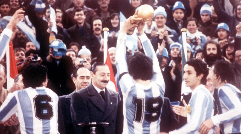 FILE - Argentine President Jorge Rafael Videla, center, looks on after he presented the World Cup Trophy to Argentina's captain Daniel Passarella (19), at the presentation ceremony following the World Cup final soccer match against the Netherlands in the River Plate Stadium in Buenos Aires, June 25, 1978. (AP Photo/Heinz Ducklau)
