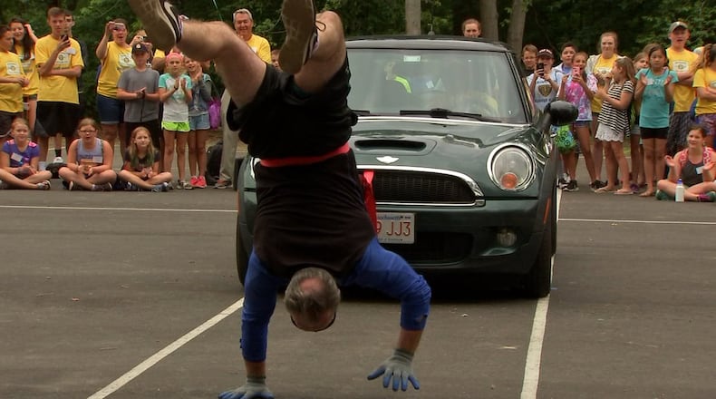 Mark Kenny pulled a car while walking on his hands to break a world's record.