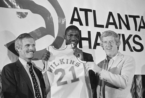 Dominique Wilkins, all-time leading scorer at the University of Georgia, holds his Atlanta Hawks jersey flanked by coach Kevin Loughery, right, and owner Ted Turner on Sept. 4, 1982, in Atlanta. (Joe Holloway/AP File)